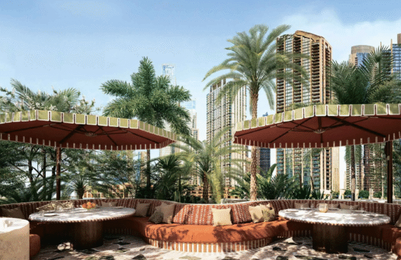 Outdoor lounge and seating area with lush greenery and a view of the Dubai cityscape .