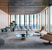 Modern living area with stylish seating and ocean view through floor-to-ceiling windows.