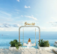 Luxury amenity area featuring an outdoor swing, lounge chairs, and an expansive sea view under a clear sky.