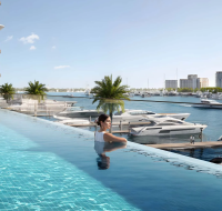 Infinity pool overlooking a vast body of water filled with luxury yachts .