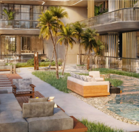 Outdoor lounge area with modern seating, palm trees, and decorative water feature in a residential courtyard