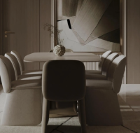 A modern dining area with an oval table and plush chairs.