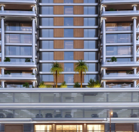 A modern high-rise with glass façades, layered balconies, and landscaped terraces with palm trees.