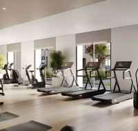 Bright fitness center featuring large windows and garden views