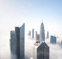 The iconic Dubai skyline with the Burj Khalifa visible above a blanket of fog
