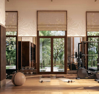 Modern fitness and wellness center with exercise equipment overlooking landscaped gardens.