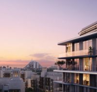 Modern luxury residential building with spacious balconies overlooking a city skyline at sunset.