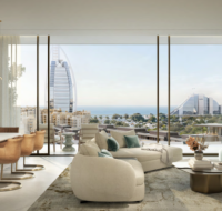 Bright, open-plan residential space with a curved sofa and dining table, overlooking a prominent sail-shaped skyscraper.