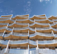 Modern residential building exterior with curved, wave-like balconies and wood-like ceilings.