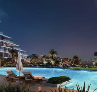 Contemporary residential complex with a terraced facade, surrounded by palm trees and an outdoor pool deck.