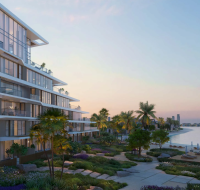 Modern beachfront residential development by Nakheel featuring contemporary architecture, glass facades, and palm-lined shore.