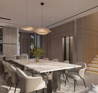 Modern dining area with marble table, velvet chairs, chandelier, and wood-paneled walls by the kitchen bar.