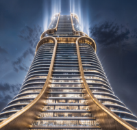 A futuristic skyscraper illuminated at night, with upward-shining lights and a unique curved architectural design .