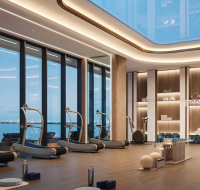An elegant fitness center with a vaulted skylight, wooden floors, and ocean views.
