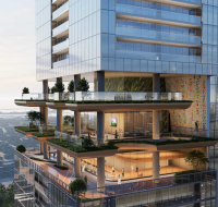 Waterfront dining promenade at Sobha SkyParks, SZR, with tables and palm trees at dusk.