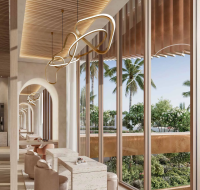 Bright, modern interiors with arched doorways, nude seating, distinctive lighting, and floor-to-ceiling windows overlooking a lush tropical garden.