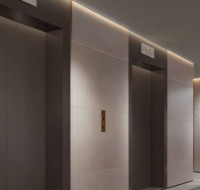 Residential building lobby featuring multiple elevators and a clean, minimalist design.