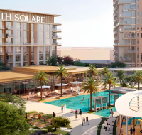 Modern residential complex beside lagoon with walking trails and greenery