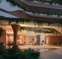 Green park with palm trees and benches beside residential tower