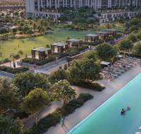 An aerial view of the long communal swimming pool and central park amenity area in the Dubai South community.