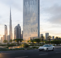 Tall glass skyscraper in a vibrant urban setting with a city skyline in the distance