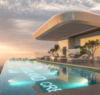 Infinity rooftop pool with lounge chairs and sunset view